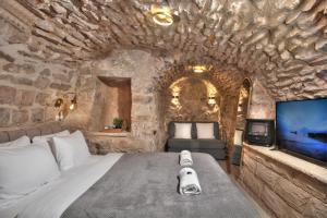 a bedroom with a large bed in a stone wall at סוויטת גן עדן - Gan Eden Suite in Safed