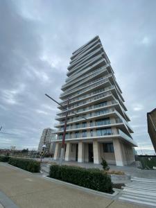 Un palazzo alto con un palo davanti di Casa Aninka a Ostenda