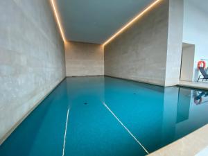an indoor swimming pool with blue water in a room at Casa Aninka in Ostend