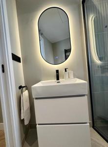 a bathroom with a white sink and a mirror at Central Apt de 2hab para 5pax en Calle Silva in Madrid