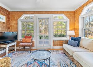 a living room with a couch and a tv at The Burkeshire Manor - Charming Family Home in Oak Bluffs