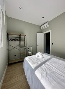 a bedroom with a large white bed and a shelf at Central Apt de 2hab para 5pax en Calle Silva in Madrid