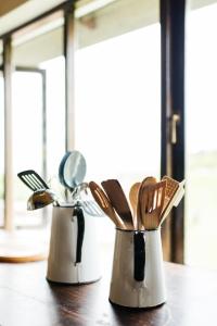 three metal utensils sitting on a wooden table at The Cowshed in Lydenburg
