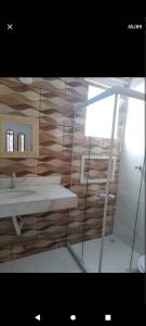 ein Bad mit einem Waschbecken und einem Spiegel in der Unterkunft Ramos Acomodações in Búzios