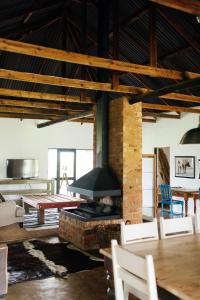 a living room with a fireplace and a table at The Cowshed in Lydenburg