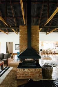 a fireplace in the middle of a living room at The Cowshed in Lydenburg