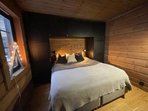 a bedroom with a bed with a wooden wall at Idre Mountain Lodges with 11 beds in Idre