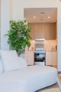 un canapé blanc dans une cuisine avec une plante dans l'établissement LUXFolio Retreats - Full Marina View - Brand New, à Dubaï