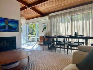 a living room with a dining table and a tv at Sandy Bay Haven in Sandy Bay