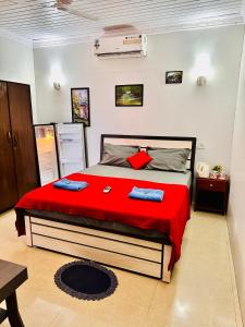 - une chambre avec un grand lit et une couverture rouge dans l'établissement Blue Mirage Palolem Goa, à Canacona