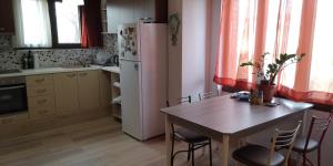 eine Küche mit einem Tisch und einem Kühlschrank in der Unterkunft Μονοκατοικία Σουρωτή in Sourotí
