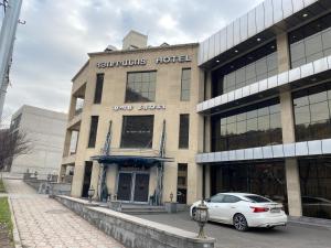 un coche blanco estacionado frente a un edificio en SpaHotel en Ereván