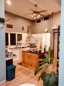 een grote keuken met een groot eiland in een kamer bij บ้านบนภู ปากช่อง พลูวิลล่า - with a housekeeper in Ban Lam Thong Lang