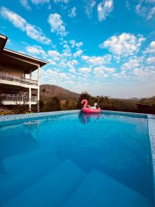 een groot zwembad met een roze opblaasbaar zwembad bij บ้านบนภู ปากช่อง พลูวิลล่า - with a housekeeper in Ban Lam Thong Lang