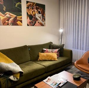 a living room with a green couch and a table at Hotel Schlossberg in Badenweiler