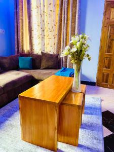 a living room with a vase of flowers on a table at Tin apartment Tanga in Tanga