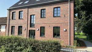 a red brick building with black windows at Ferienwohnungen Hamminkeln, Berg4Home in Hamminkeln