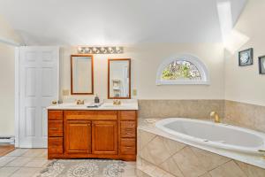 a bathroom with a tub and a sink at The Burkeshire Manor - Charming Family Home in Oak Bluffs +43 photos
