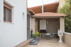 un patio al aire libre con pérgola de madera en Villa Amalia Sun Beach en Nea Vrasna