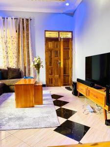 a living room with a flat screen tv and a couch at Tin apartment Tanga in Tanga