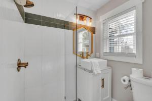 a white bathroom with a toilet and a sink at 4Bed/3bath- 1 mile to Downtown in Spartanburg +18 photos