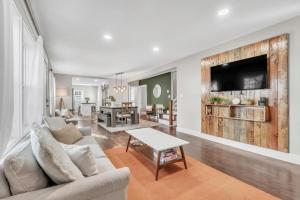 a living room with a couch and a tv on a wall at 4Bed/3bath- 1 mile to Downtown in Spartanburg