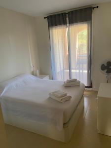 ein Schlafzimmer mit einem weißen Bett und Handtüchern darauf in der Unterkunft Vera playa martos in Vera