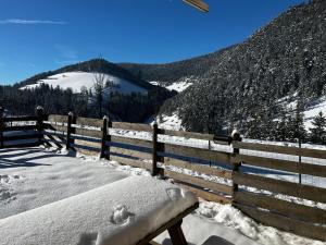 a bench covered in snow next to a fence at Chalet de Montagne Villard de Lans in Villard-de-Lans