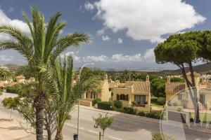 uitzicht op een straat met huizen en palmbomen bij La Manga Club Resort - Los Molinos 20 in Atamaría
