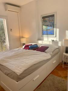 a white bed in a bedroom with a window at Villa Florence in Cavalaire-sur-Mer +27 photos
