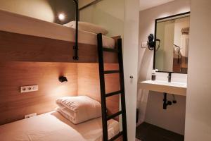 a bunk bed with a mirror and a sink in a room at TOC Hotel Las Ramblas in Barcelona