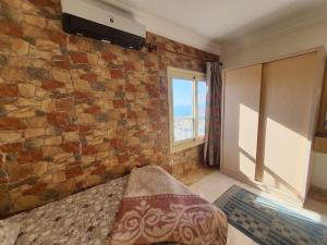een kamer met een stenen muur, een bed en een raam bij City Square - Brand New Luxury Apartment With Stunning Sea View in Alexandrië