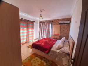 een slaapkamer met een bed in een kamer met gordijnen bij City Square - Brand New Luxury Apartment With Stunning Sea View in Alexandrië