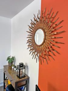 a mirror hanging on a wall with a table at Hindmarsh Apartment in Ashington