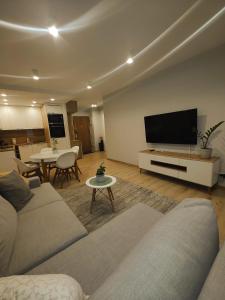 uma sala de estar com um sofá e uma televisão de ecrã plano em Maya's Flats & Resorts 42 - Świętej Barbary em Gdansk