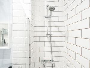 a shower with white subway tiles in a bathroom at Pass the Keys Unique Grade II Listed Flat in Liverpool Parking in Knowsley