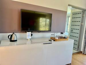 a flat screen tv on top of a white counter at Pure Guest House in Hout Bay
