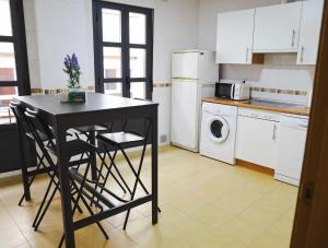 a kitchen with a table and chairs and a refrigerator at 33 Pasos Catedral 2 in León