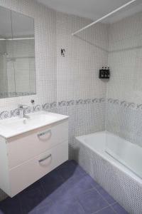 bagno con lavandino bianco, vasca e specchio di 33 Pasos Catedral 2 a León