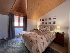 ein Schlafzimmer mit einem großen Bett und einem Fenster in der Unterkunft Kinohaus 7 in Wengen