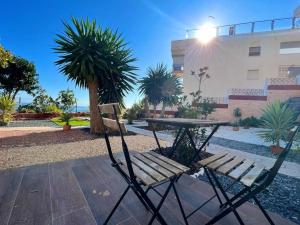 een picknicktafel en een bank naast een gebouw bij Central Torremolinos Garden Apartment - Sea Views in Torremolinos