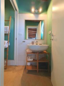 łazienka z umywalką i zieloną ścianą w obiekcie La Casetta di Angela w mieście Rivarolo Canavese
