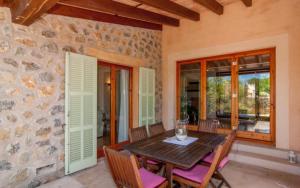 a dining room with a wooden table and chairs at Es Romagueral in Artá