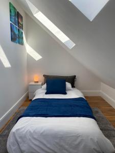 a bedroom with a large bed with a blue pillow at Saxon House, sleeps 5, free parking in London