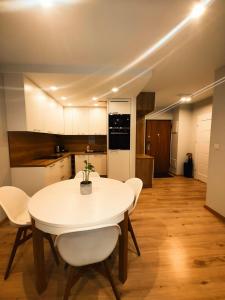 uma cozinha e sala de jantar com uma mesa branca e cadeiras em Maya's Flats & Resorts 42 - Świętej Barbary em Gdansk