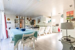 ein Esszimmer mit einem blauen Tisch und weißen Stühlen in der Unterkunft Villa Cap Ferret - Réf 230 in Lège-Cap-Ferret
