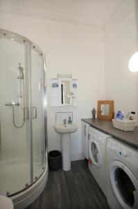 a bathroom with a washing machine and a sink at Loveliest Homes Paignton - Wavecrest Apartments - mixed sizes - parking in Paignton