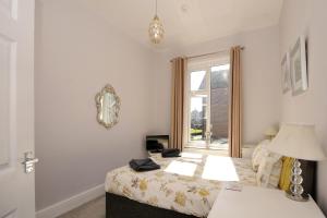 1 dormitorio con cama y ventana en Loveliest Homes Paignton - Wavecrest Apartments - mixed sizes - parking en Paignton