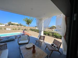eine Terrasse mit Stühlen, einem Tisch und einem Pool in der Unterkunft Casa Isabelle Caials in Cadaqués