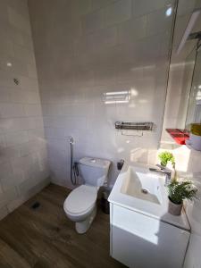 a white bathroom with a toilet and a sink at F3 Appartement Point E Dakar in Dakar
